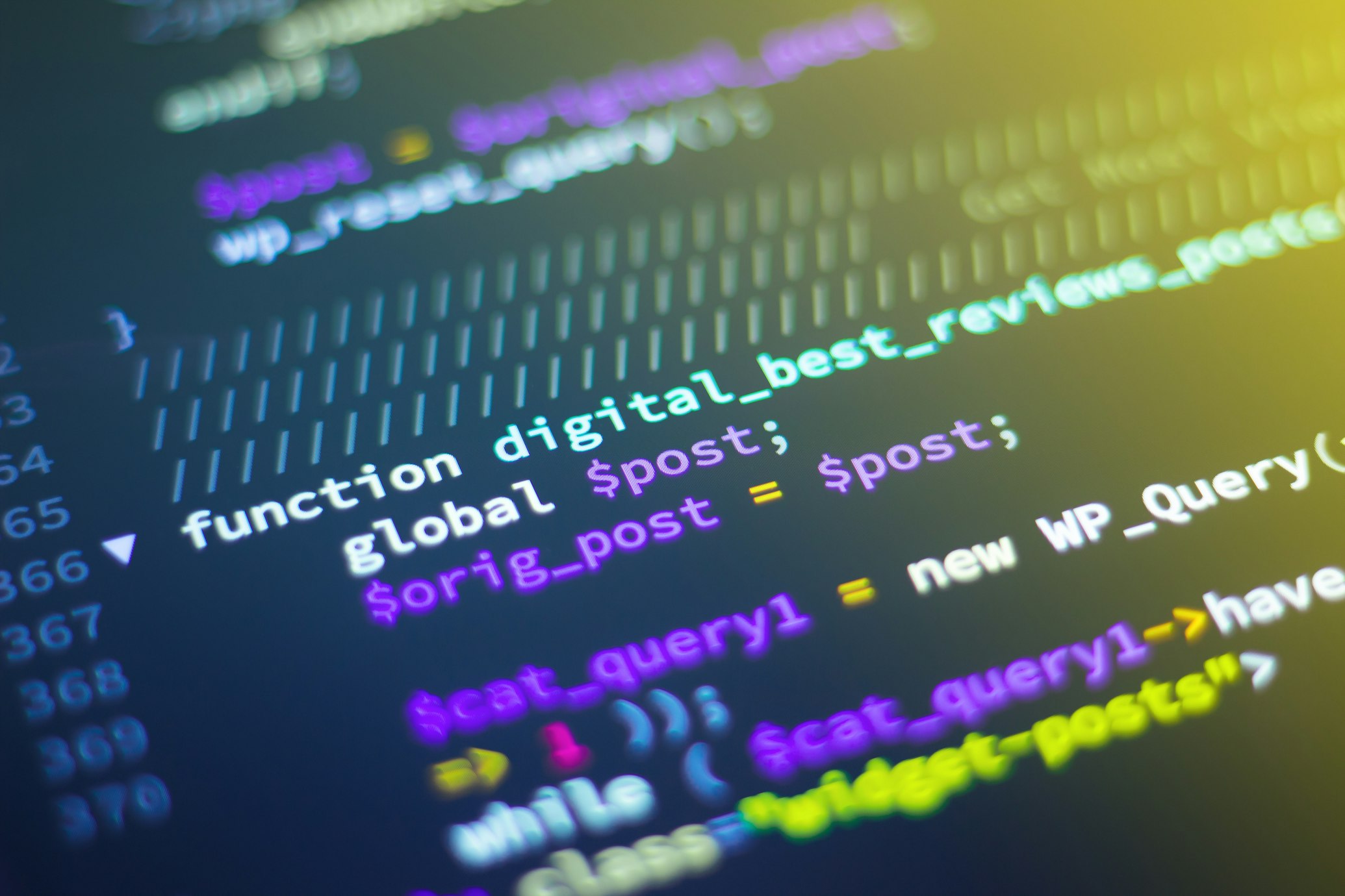 Close up view of glowing green and blue code on a dark computer monitor, hacker or developer environment